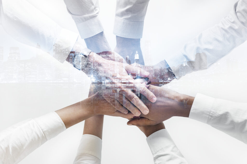 business team joining hands together city background